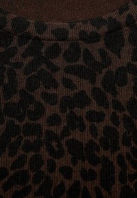 Tejido de color marrón acanalado con un patrón de estampado de leopardo negro que presenta manchas de tamaños variados. La textura parece suave y ligeramente elástica.