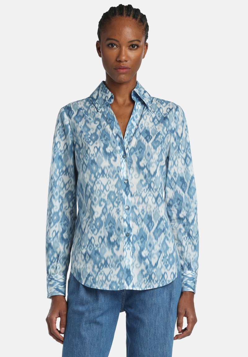 Košeľa s dlhým rukávom v odtieňoch modrej s abstraktným vzorom. Vyrobená z hladkého materiálu, s golierom na gombíky a jemným leskom.