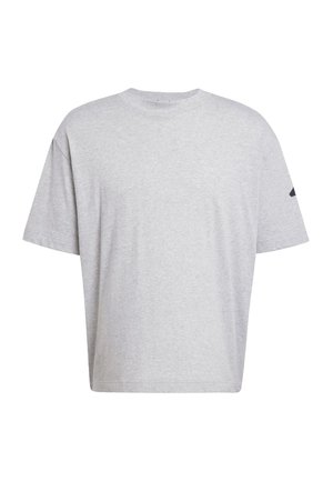 Siva pamučna majica s opuštenim krojem, kratkim rukavima i okruglim izrezom. Ima mali crni logotip na jednom rukavu.