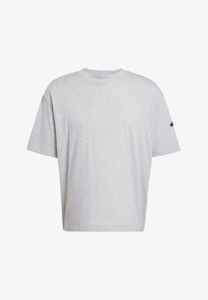 Siva pamučna majica s opuštenim krojem, kratkim rukavima i okruglim izrezom. Ima mali crni logotip na jednom rukavu.