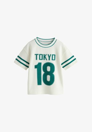 Fehér, rövid ujjú póló hálós szerkezettel. Zöld "TOKYO" és "18" felirattal, valamint zöld csíkos részletekkel az ujjain és a gallérján.