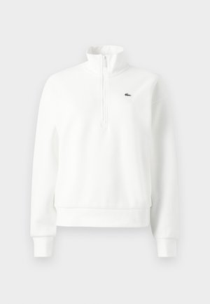 White zip-neck sweatshirt with a relaxed fit, made of soft fabric, featuring ribbed cuffs and hem, and a small green logo on the chest.