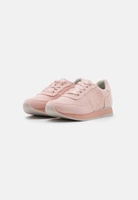 Baskets en suede rose clair avec une texture lisse, bout arrondi, fermeture à lacets et semelle crème contrastante. Design décontracté avec des accents minimalistes.