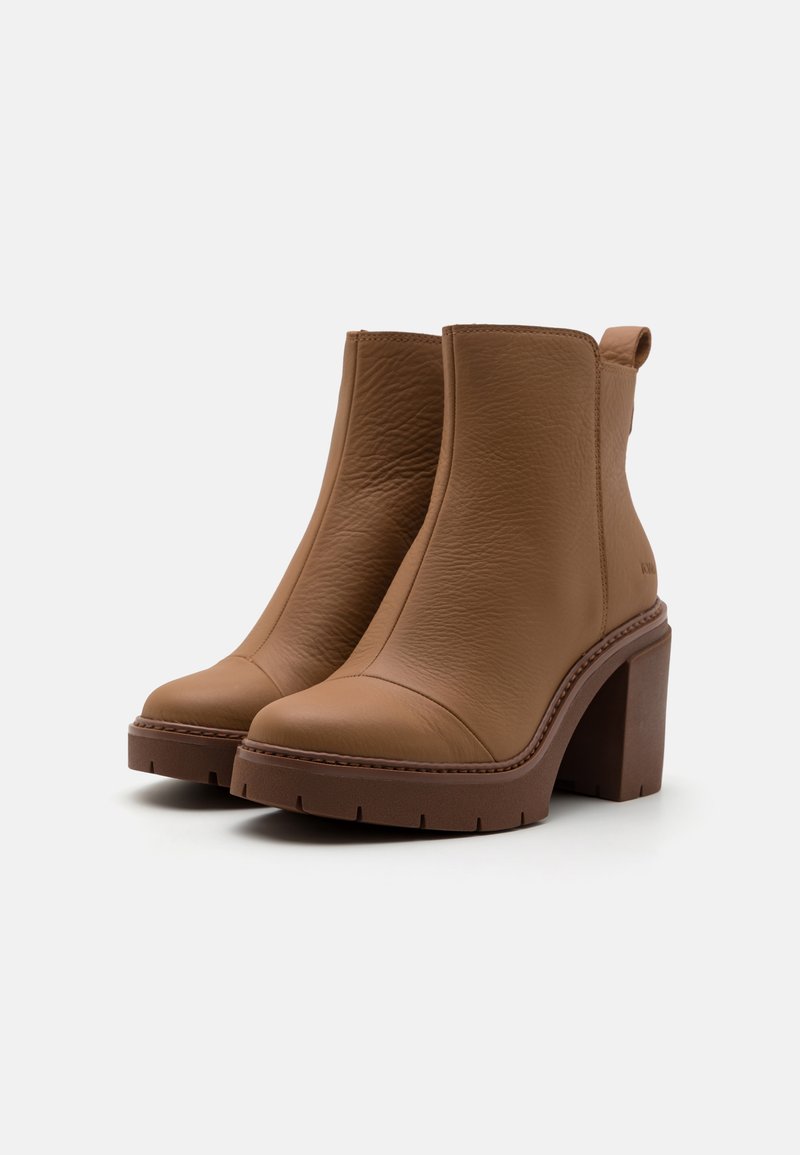 Braune Leder-Ankle Boots mit glatter Textur, runden Spitzen, dicken Blockabsätzen und einem seitlichen Zugband für einfaches Anziehen.