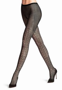 Schwarze Netzstrumpfhosen mit einem netzförmigen Muster und großen runden Öffnungen, das oben zu einem feineren Mesh übergeht. Getragen mit High-Heel-Schuhen.