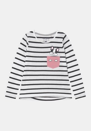 Chemise à manches longues blanche et noire à rayures avec une poche rose mettant en scène un chien de dessin animé qui dépasse sur le côté gauche devant.