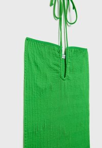 Robe en tissu côtelé vert avec un large décolleté et des bretelles réglables à nouer. Dispose d'une surface texturée et d'une coupe décontractée.