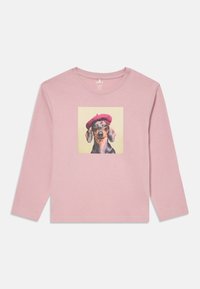 T-shirt a maniche lunghe di colore rosa in cotone. Presenta un cane stampato con un berretto rosso su uno sfondo beige quadrato. Collo rotondo.