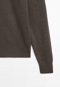 Dunkelbrauner, gerippter Pullover mit Rundhalsausschnitt und langen Ärmeln, gefertigt aus einem weichen, strukturierten Material mit engem Saum.