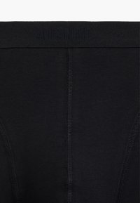 Czarne bawełniane bokserki z miękkim paskiem w talii, z wytłoczonym napisem "ATLANTIC". Gładka tekstura i minimalne detale szwów.