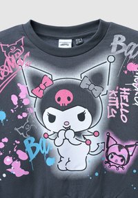 Szara bawełniana bluza z dużą, figlarną postacią w czarne i różowe akcenty, otoczoną kolorowymi wzorami plam i tekstem.