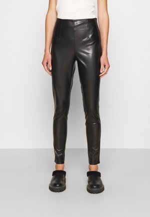 Pantaloni in pelle nera con vita alta, gambe affusolate e pince frontali. Presentano una texture lucida e un design aderente e slanciato.