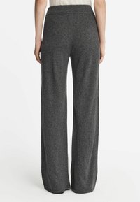 Donkergrijze, wijdvallende, gebreide broek met een zachte textuur en een elastische tailleband, met een nette afwerking aan de zoom en zonder zakken.