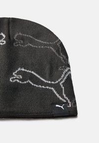 Berretto a maglia nera con un motivo testurizzato e logo Puma bianco a contrasto. Presenta un design aderente e un tessuto morbido.