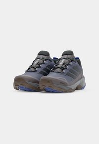 Chaussures de randonnée GORE-TEX grises avec des accents noirs, dotées d'une semelle robuste, d'un bout rond, d'un col rembourré et d'un lacet.