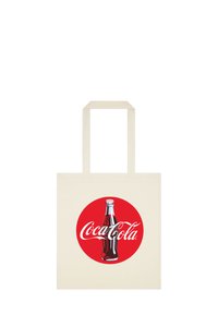 Bawełniana torba na ramię w kolorze kremowym, z czerwoną okrągłą logo Coca-Cola oraz ilustracją butelki i białym tekstem. Płaska, bez dodatkowych akcentów.