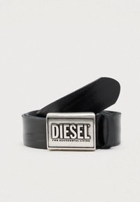 Cinturón de cuero negro con una hebilla rectangular plateada que lleva el nombre de la marca "DIESEL" y la frase "FOR SUCCESSFUL LIVING". Textura lisa.