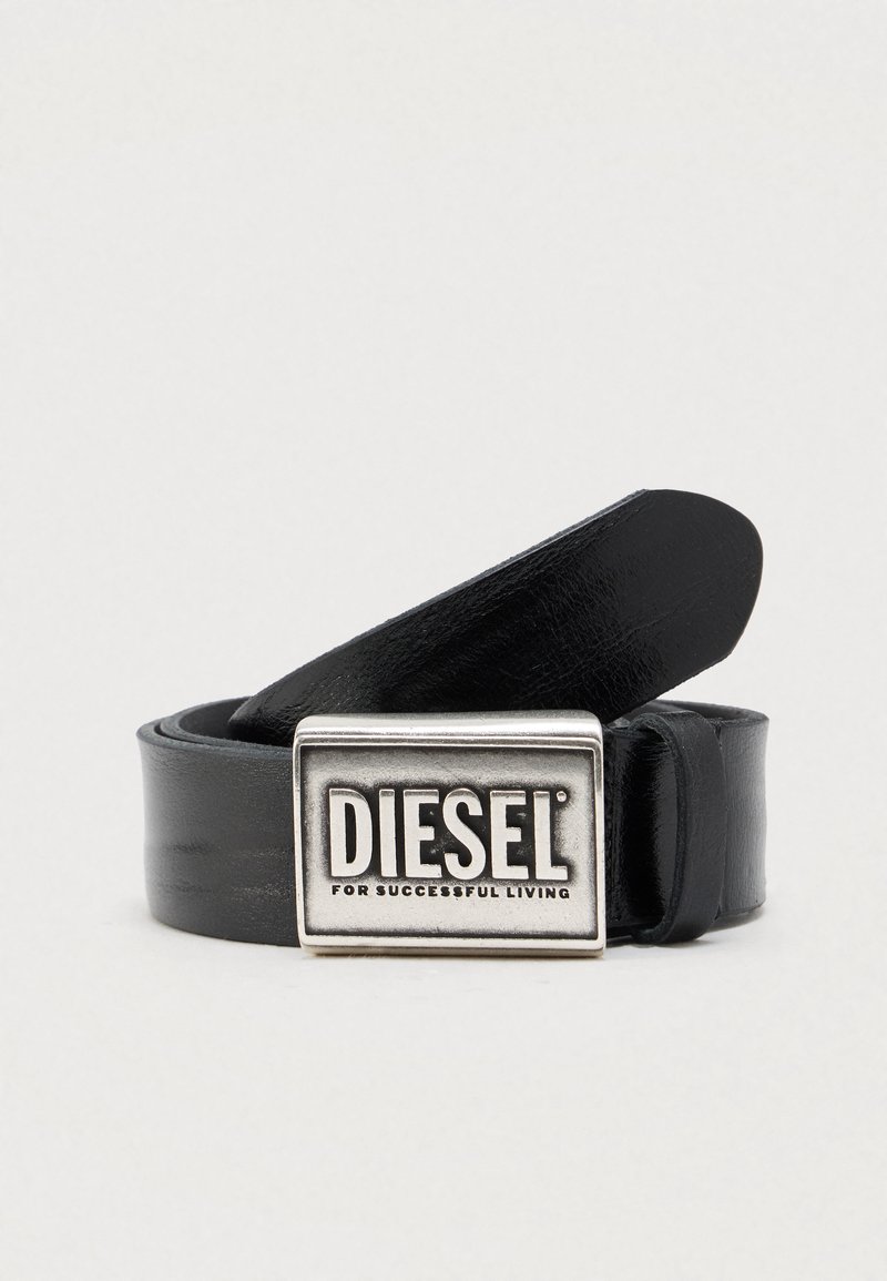 Cinturón de cuero negro con una hebilla rectangular plateada que lleva el nombre de la marca "DIESEL" y la frase "FOR SUCCESSFUL LIVING". Textura lisa.