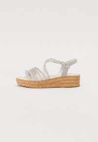 Silver strappy sandals with a wedge heel, featuring a textured cork sole and a single adjustable ankle strap. Smooth interior design.