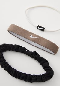 Prikazane su tri gumice za kosu: crna elastična scrunchie, tanka smeđa trakica s reflektivnim logom i bijela elastična trakica s logom.