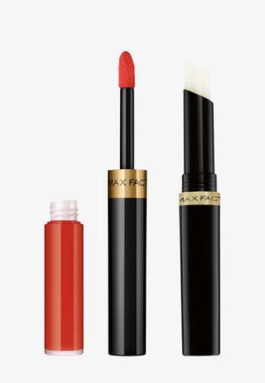 El set de productos para labios de Max Factor incluye un tubo transparente con lápiz labial líquido rojo y aplicador de esponja, un tubo negro con aplicador plano y la marca visible.