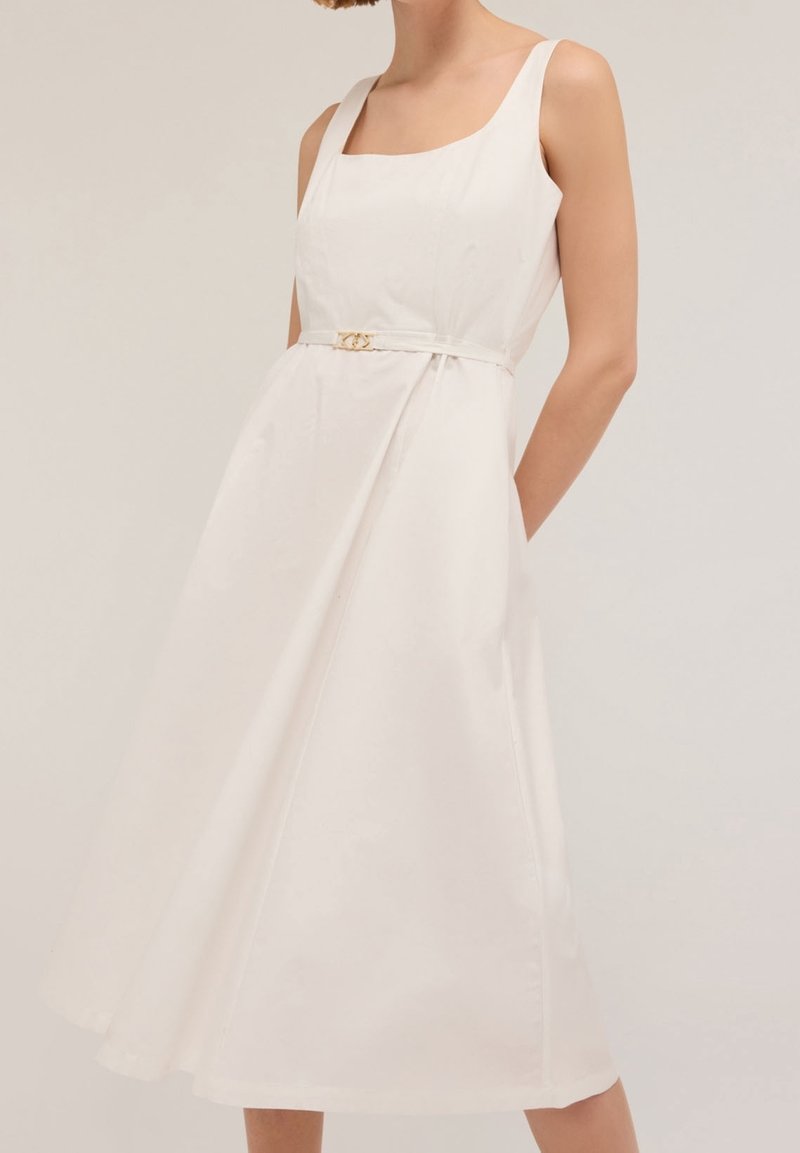 Witte midi-jurk met een vierkante halslijn, verstelbare schouderbanden en een fitted taille die wordt geaccentueerd door een gouden riemdetail. Gladde stof.