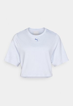 Fehér, rövid ujjú, cropped póló, kerek nyakkivágással és egy kis kék Puma logóval a mellkason. Sima szövet textúra.