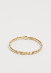 Bracelet en métal doré à tonalité avec un design en spirale serrée et une texture lisse. Le fermoir est intégré à la structure du bracelet.