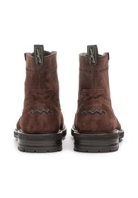 Stivaletti alla caviglia in suede marrone con un design a zigzag sul tallone, perforazioni decorative e una suola in gomma nera con una finitura testurizzata.