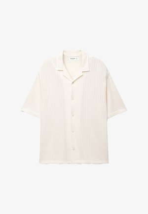 Camicetta a maniche corte color crema, caratterizzata da un motivo in maglia testurizzata, colletto a punta e cinque bottoni sul davanti per la chiusura.