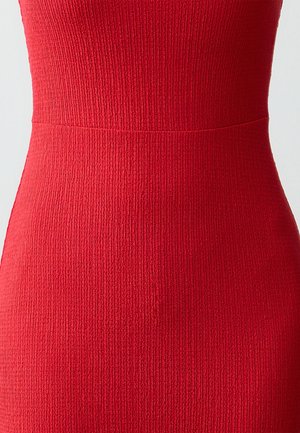 Rotes geripptes Kleid mit taillierter Oberweite und strukturiertem Stoff. Nahtloses Design mit einem subtilen Übergang der Taille. Keine zusätzlichen Beschläge.