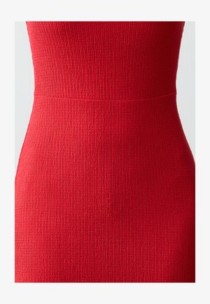 Rotes geripptes Kleid mit taillierter Oberweite und strukturiertem Stoff. Nahtloses Design mit einem subtilen Übergang der Taille. Keine zusätzlichen Beschläge.