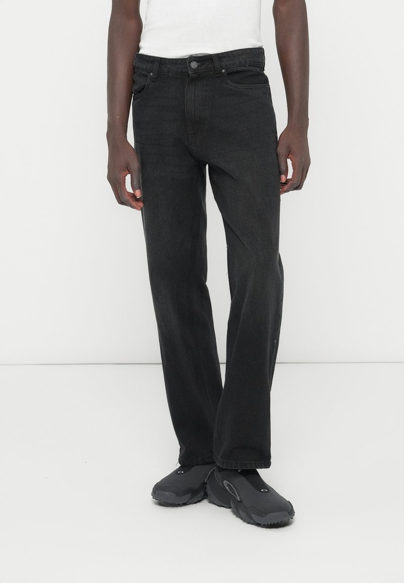 Fekete egyenes szárú farmernadrág klasszikus szabással, farmer anyagból készült, elülső és hátsó zsebekkel, gombos záródással és finom varrási részletekkel.