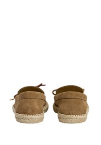 Espadrilles en suède marron avec une semelle en jute tressé et des sangles à l'arrière de la cheville, présentant une texture lisse et une forme arrondie.