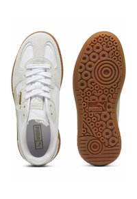 Weiße Sneaker aus Wildleder und Leder, mit runder Zehenform, goldenen Akzenten und einer strukturierten braunen Gummisohle mit kreisförmigen Mustern.