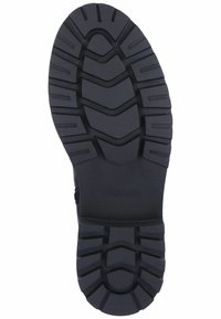 Semelle de chaussure en caoutchouc noir avec un motif de semelle texturé et multi-directionnel ainsi qu'un logo. Comprend des rainures profondes pour une adhérence et une stabilité accrues.