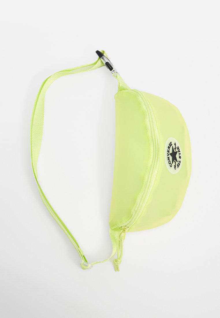 Riñonera de color amarillo neón con cierre de cremallera, correa ajustable y un parche de logo circular con un diseño de estrella. Material suave y brillante.