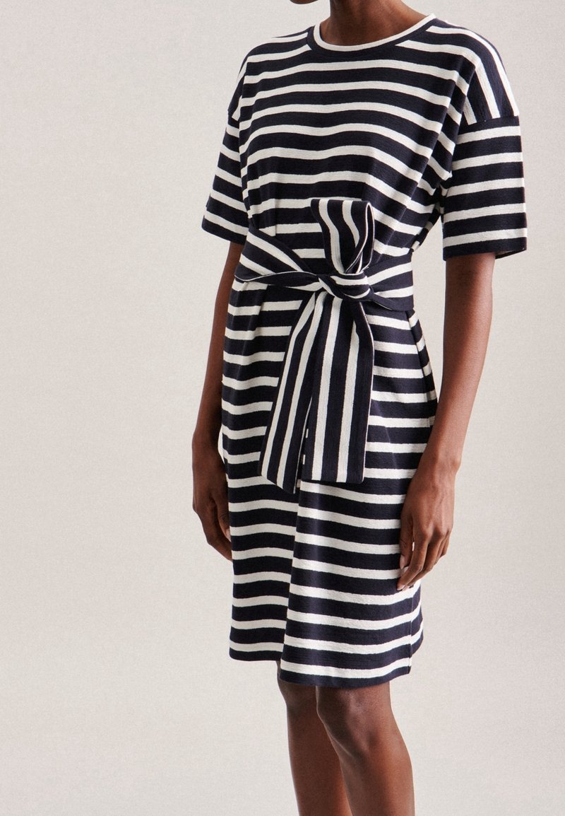 Abito a righe in cotone blu navy e bianco, con scollo rotondo, maniche corte e un dettaglio in vita annodato per un look aderente.