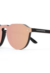 Schwarze Sonnenbrille mit runden, pinken, verspiegelt Glaslinsen. Verfügt über ein einzigartiges geometrisches Rahmendesign und metallische Seitendetails. Markennamen "HAWKERS" an den Bügeln angebracht.