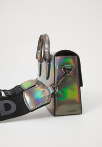 Holographic handbag with a rectangular shape, glossy finish, two top handles, and a detachable strap featuring a texture and colorful sheen.