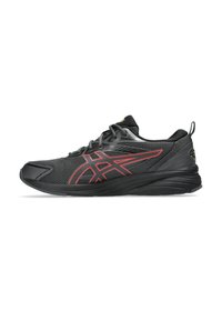 Chaussure de sport noire avec des accents rouges, dessus en mesh, semelle en caoutchouc et col rembourré. Caractéristiques d'une semelle à motif multidirectionnel pour une meilleure traction.