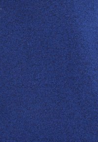 Tissu bleu avec une texture lisse, présentant un motif de tricot uniforme et une distribution de couleur homogène, adapté à diverses utilisations textiles.