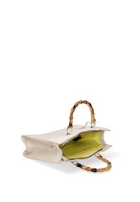 Borsa a mano in pelle beige con manici simili al bambù, chiusura con zip e fodera interna verde. La borsa presenta una forma strutturata e una texture liscia.