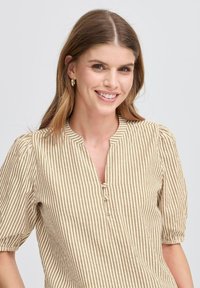 Beige og brun stribet bluse med korte puffærmer, en V-halsudskæring og to knapper foran. Strukturert stof med vandrette linjer.