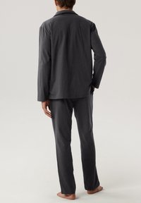 Szary bawełniany zestaw piżamowy z długim rękawem, składający się z koszuli zapinanej na guziki oraz pasujących spodni, o luźnym kroju i minimalistycznym wzornictwie.