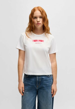 White cotton cropped t-shirt featuring a graphic design with pink eyes and text "Make boys cry" in the center. Short sleeves, relaxed fit.
