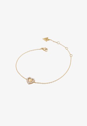 Zlatna narukvica s lancem koja sadrži privjesak u obliku srca ukrašenog prozirnim kristalima i ugraviranim natpisom "Guess." Uključuje kopču na mehanizam jastreba i podesivu duljinu.