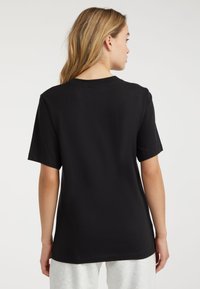 Sort bomulds T-shirt med korte ærmer, rund halsudskæring og afslappet pasform. Glat tekstur, ingen synlige mønstre eller detaljer.