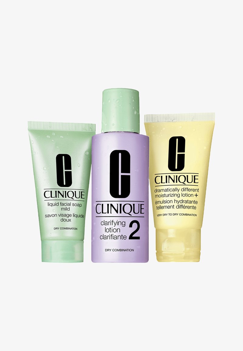 Drie Clinique huidverzorgingsproducten: een groene tube vloeibare gezichtszeep, een paarse fles met clarifying lotion en een gele tube hydraterende lotion.