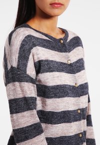 Cardigan a righe in rosa chiaro e grigio scuro, con scollatura rotonda, chiusura frontale con bottoni e texture in maglia morbida.